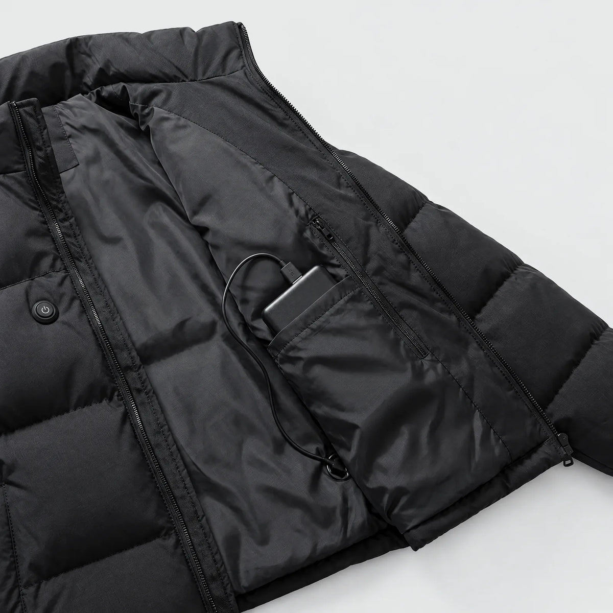 Innentasche der beheizten Steppjacke mit Reißverschluss und Powerbank, außen der Knopf auf der Brust