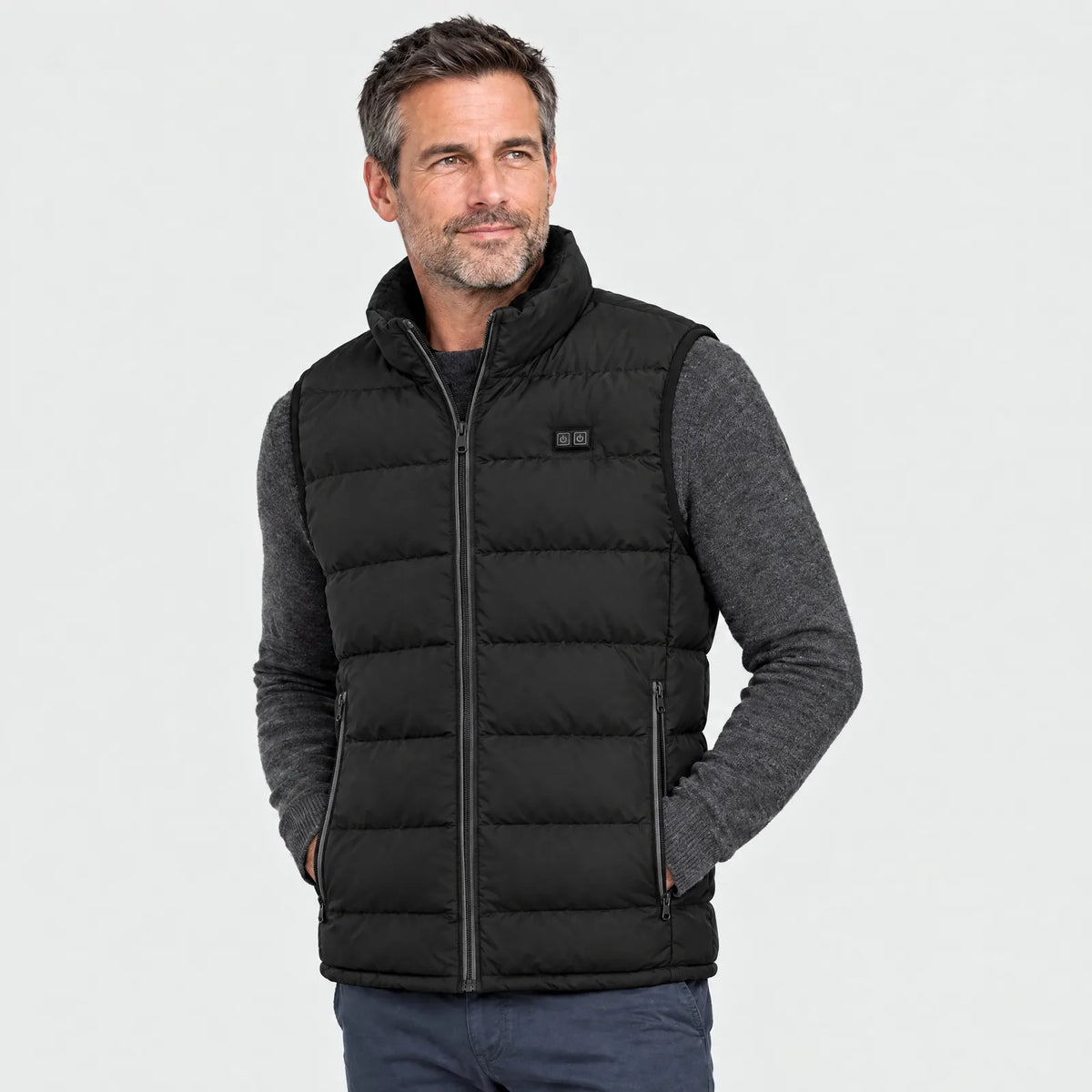 Mann trägt die schwarze Heizweste über einem grauen Pullover, Ansicht von vorn